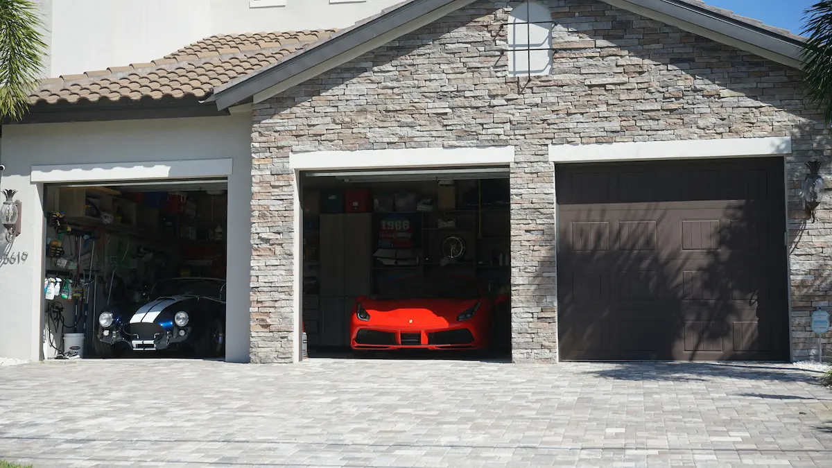 Vehicles parked inside a residential garage with sectional garage door