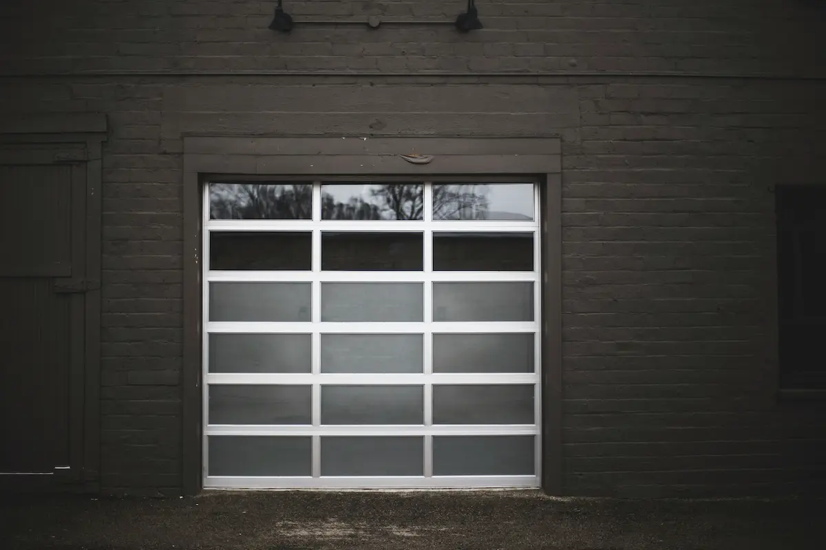 Sectional garage door with windows and connected panel hardware
